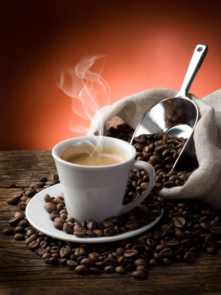 Tasse Kaffee mit Dampf und Kaffeebohnen Tasse Kaffee mit Dampf und Kaffeebohnen