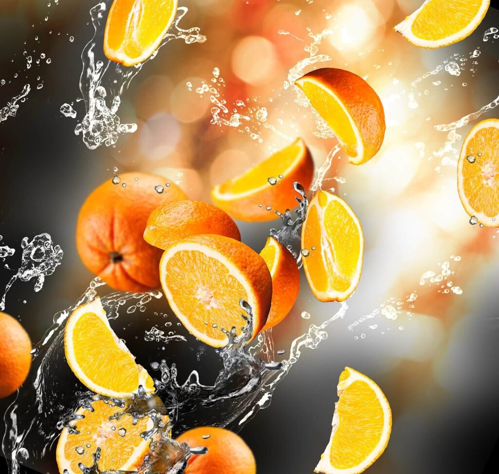 Ins Wasser fallende Orangen mit Wasserspritzern Ins Wasser fallende Orangen mit Wasserspritzern