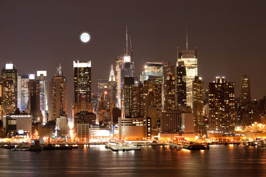 Skyline der Stadt bei Nacht mit dem Mond am Himmel