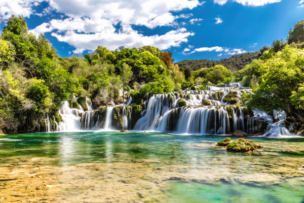 Krka-Nationalpark, umgeben von Bäumen und blauem Himmel Krka-Nationalpark, umgeben von Bäumen und blauem Himmel