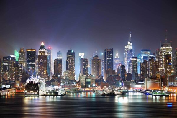 Skyline der Stadt bei Nacht mit sich auf dem Wasser spiegelnden Lichtern Skyline der Stadt bei Nacht mit sich auf dem Wasser spiegelnden Lichtern