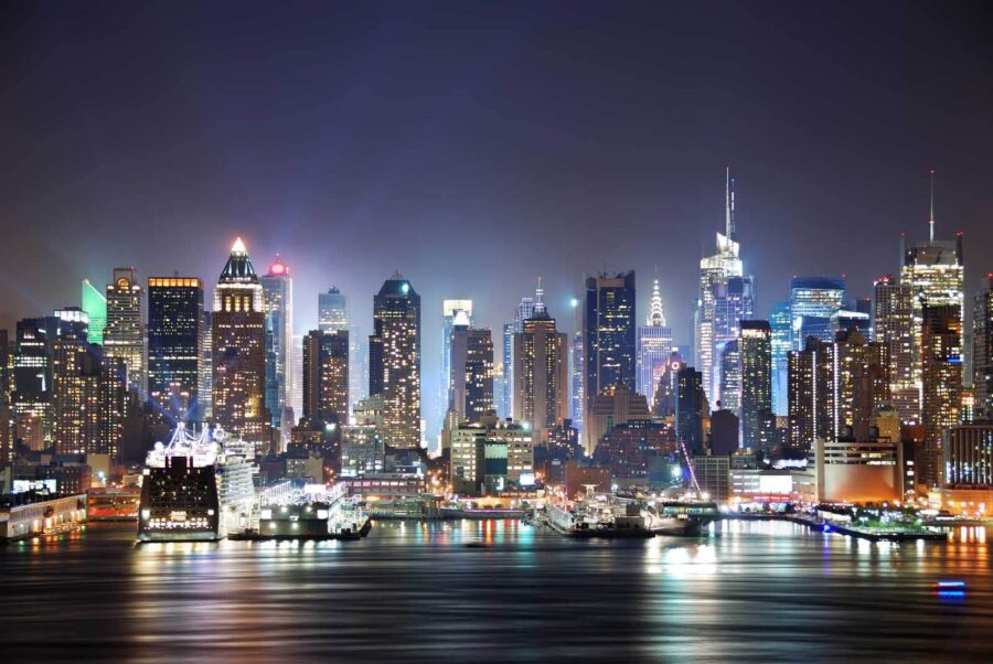 Skyline der Stadt bei Nacht mit sich auf dem Wasser spiegelnden Lichtern
