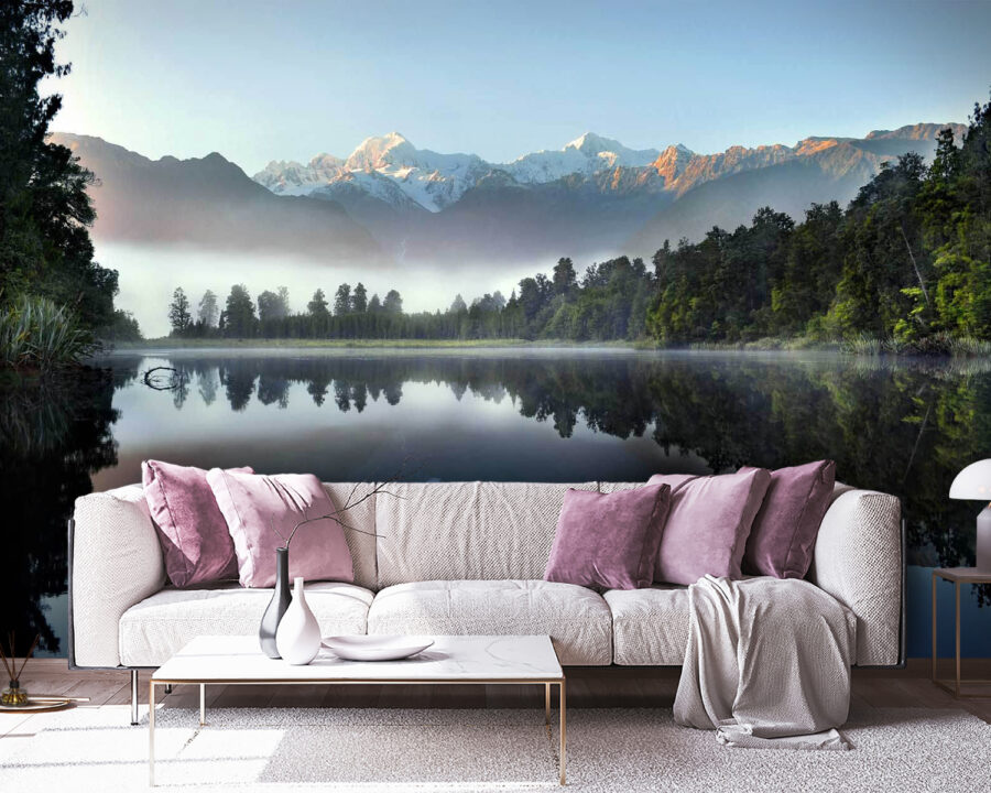 See mit Bäumen und Bergen im Hintergrund