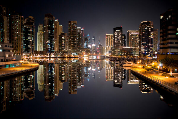 Skyline der Stadt mit sich auf dem Wasser spiegelnden Lichtern Skyline der Stadt mit sich auf dem Wasser spiegelnden Lichtern