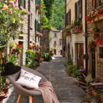 Fototapeten Schmale Straße mit Blumen und Pflanzen am Straßenrand