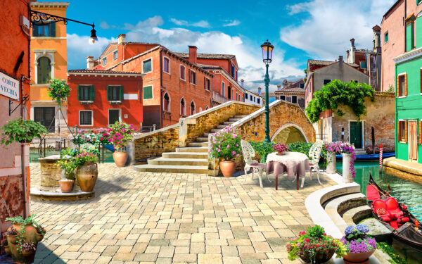 Terrasse mit Tisch und Stühlen und einem Springbrunnen vor einem Gebäude Terrasse mit Tisch und Stühlen und einem Springbrunnen vor einem Gebäude