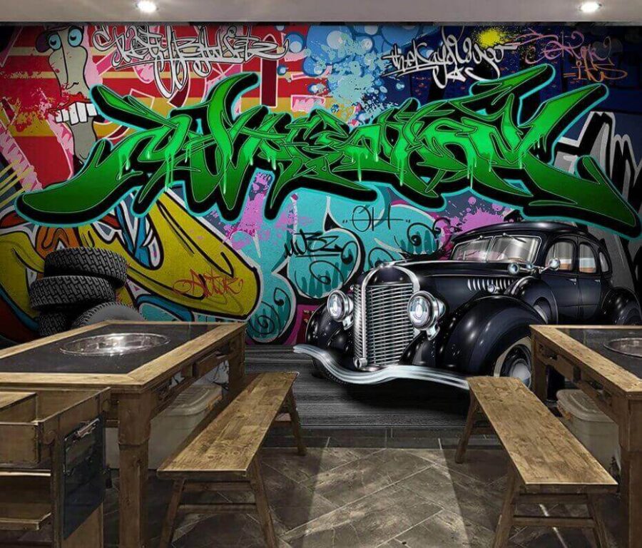 Schwarzes Auto mit Rädern vor einer bunten Wand Schwarzes Auto mit Rädern vor einer bunten Wand