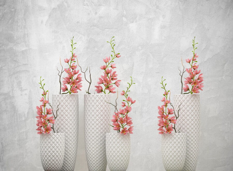 Gruppe von weißen Vasen mit rosa Blumen Gruppe von weißen Vasen mit rosa Blumen