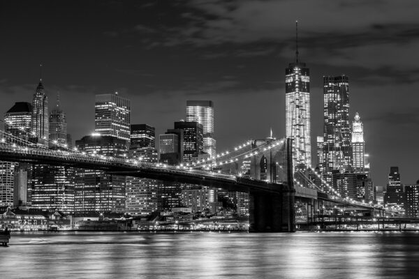 Brücke über das Wasser mit nächtlicher Stadtsilhouette Brücke über das Wasser mit nächtlicher Stadtsilhouette