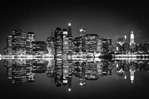 Skyline der Stadt bei Nacht mit sich auf dem Wasser spiegelnden Lichtern Skyline der Stadt bei Nacht mit sich auf dem Wasser spiegelnden Lichtern