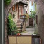 Fototapeten Steinbogen mit Pflanzen und Treppe