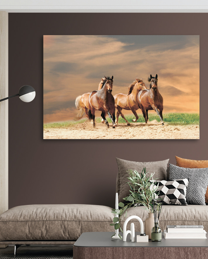 A group of horses running on a dirt road