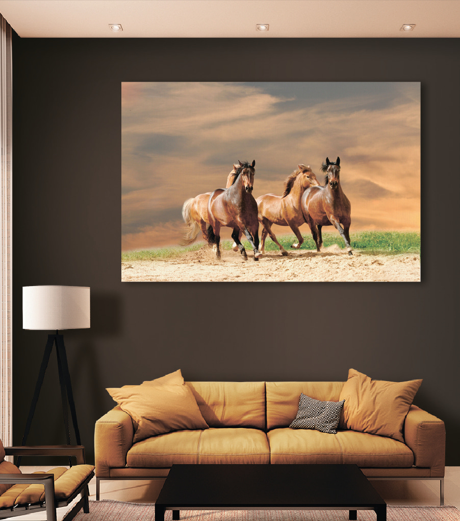 A group of horses running on a dirt road