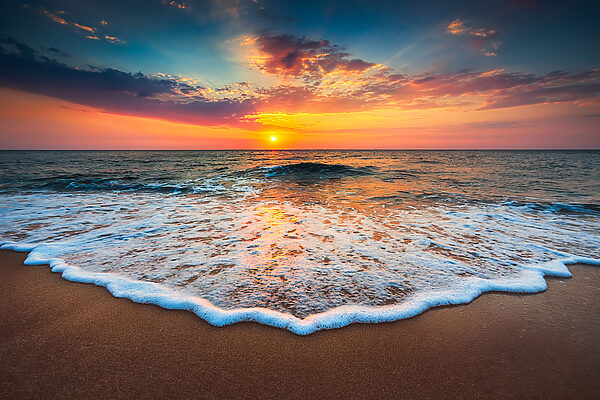 Ein Sonnenuntergang über einem Strand Ein Sonnenuntergang über einem Strand