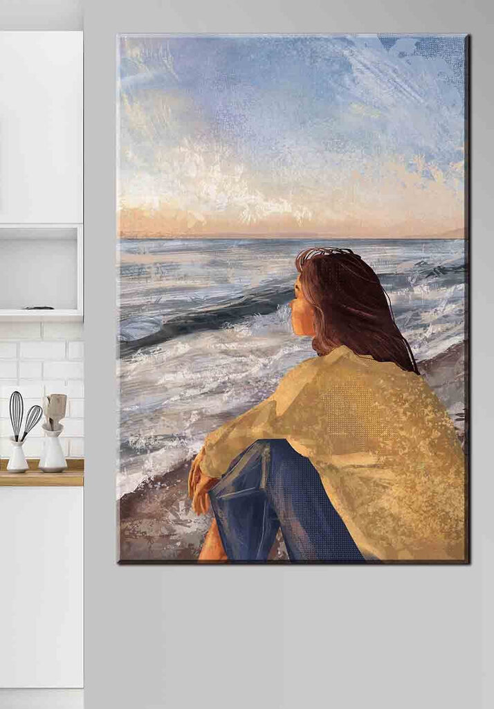 A woman sitting on a beach looking out to the ocean A woman sitting on a beach looking out to the ocean