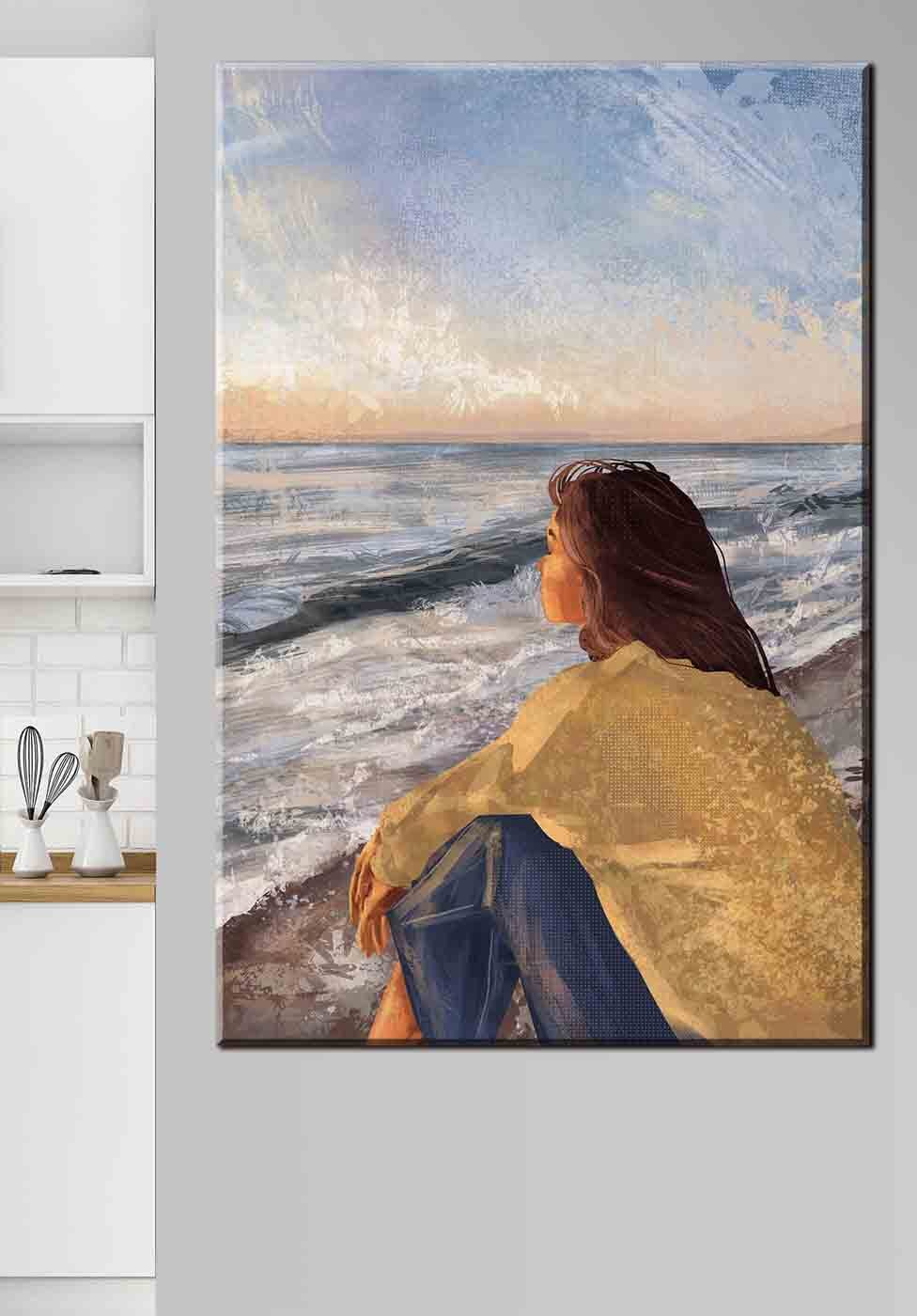 A woman sitting on a beach looking out to the ocean A woman sitting on a beach looking out to the ocean