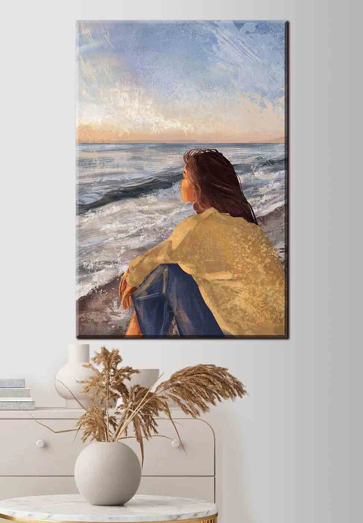 A woman sitting on a beach looking out to the ocean A woman sitting on a beach looking out to the ocean