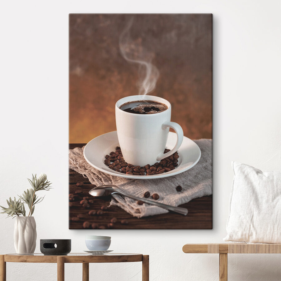 Eine Tasse Kaffee auf einem Teller mit Bohnen und einem Löffel