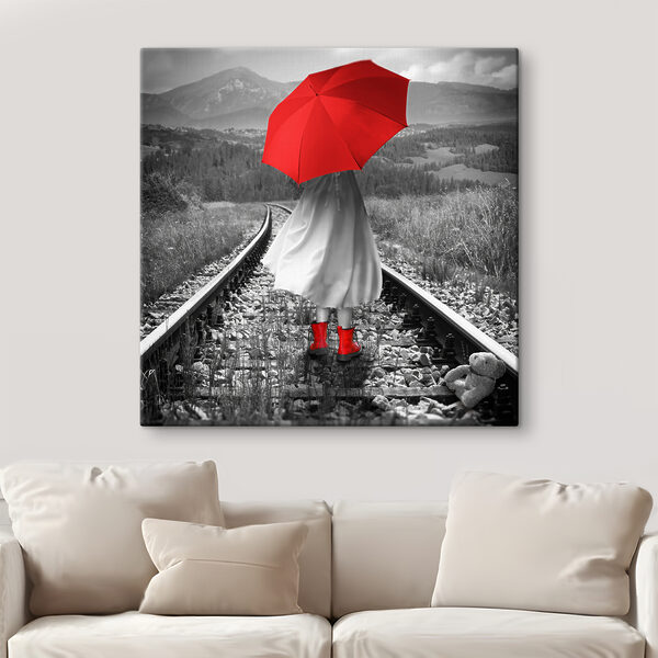 Eine Person mit einem roten Regenschirm auf einer Bahnstrecke Eine Person mit einem roten Regenschirm auf einer Bahnstrecke