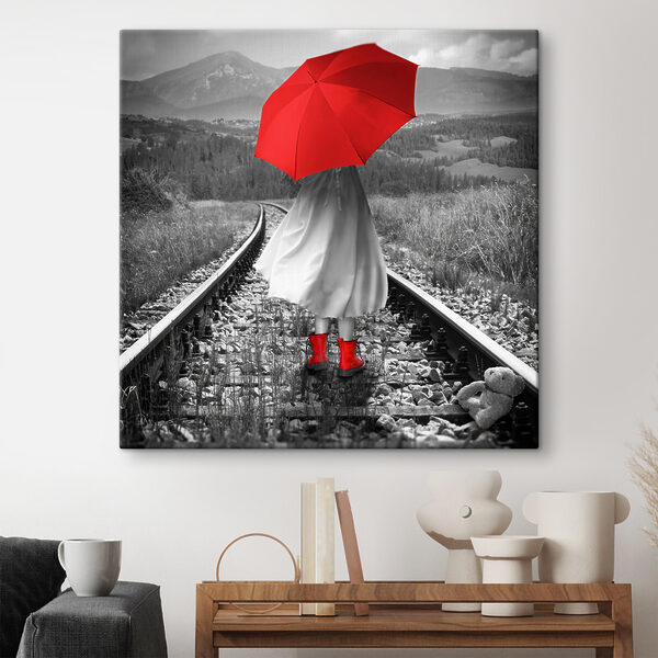 Eine Person mit einem roten Regenschirm auf einer Bahnstrecke Eine Person mit einem roten Regenschirm auf einer Bahnstrecke