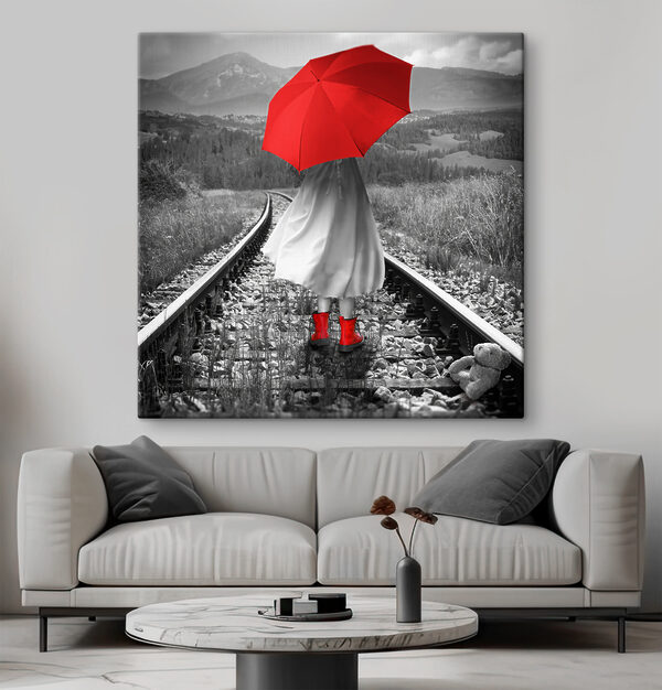Eine Person mit einem roten Regenschirm auf einer Bahnstrecke Eine Person mit einem roten Regenschirm auf einer Bahnstrecke