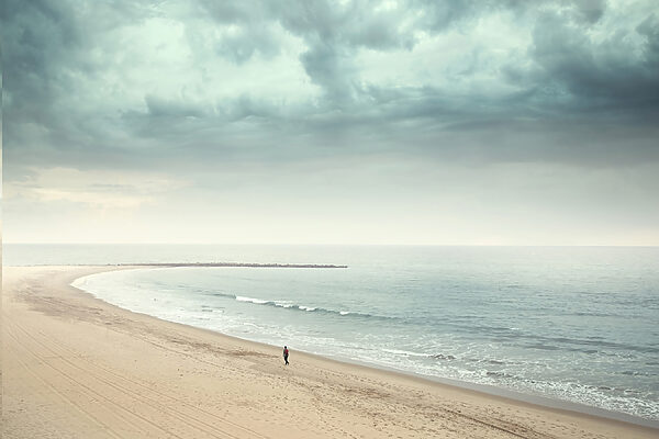 Eine Person, die an einem Strand spazieren geht Eine Person, die an einem Strand spazieren geht
