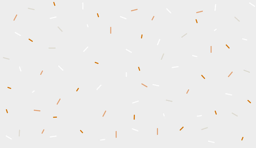 Weiße und orangefarbene Streusel auf grauem Hintergrund