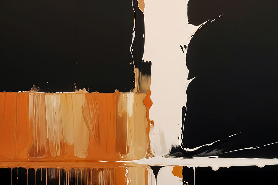 Weiße und orange Farbe tropft auf eine schwarze Oberfläche