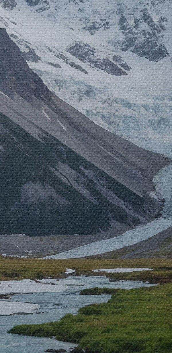 Ein Fluss fließt durch ein Tal mit schneebedeckten Bergen Ein Fluss fließt durch ein Tal mit schneebedeckten Bergen