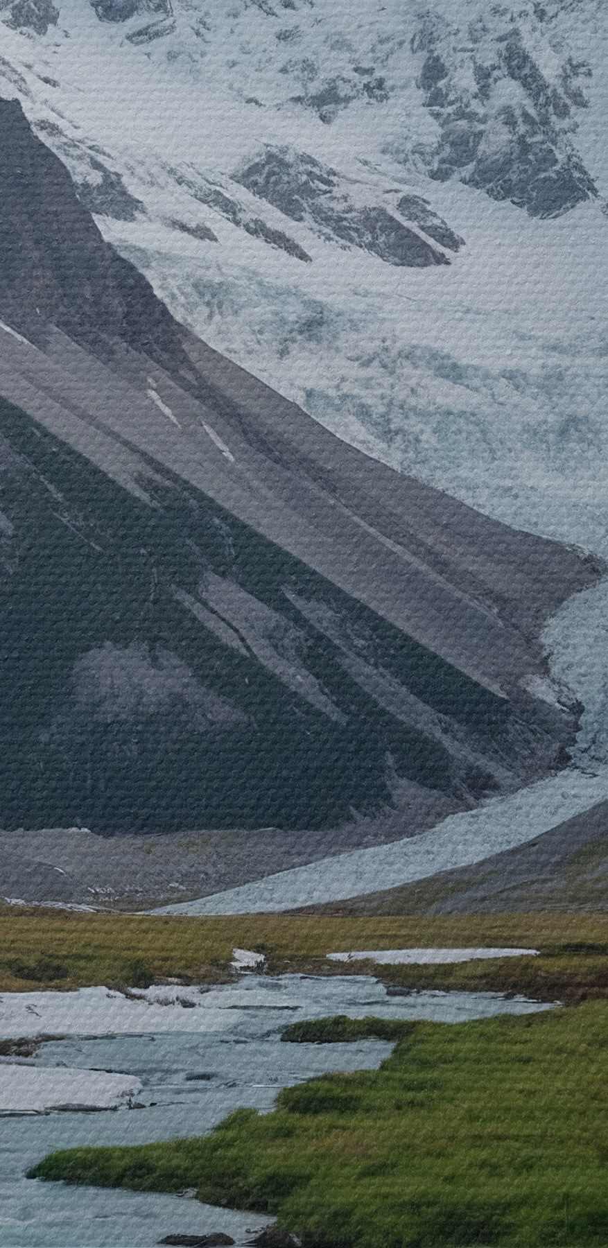 Ein Fluss fließt durch ein Tal mit schneebedeckten Bergen