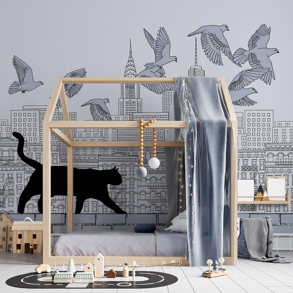 Katze, die auf einer Mauer läuft, während am Himmel Vögel fliegen