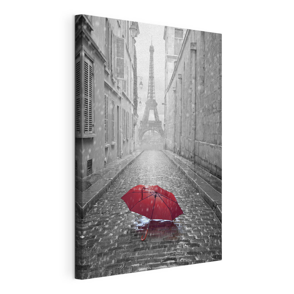 A red umbrella in a street with a tower in the background A red umbrella in a street with a tower in the background