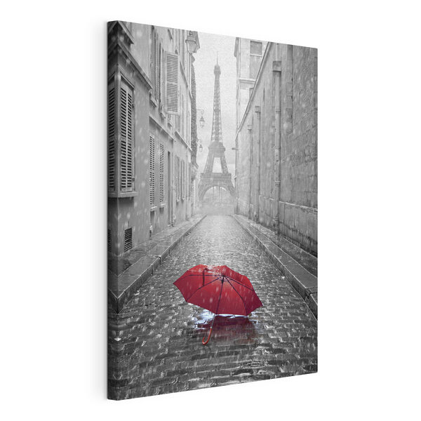 A red umbrella in a street with a tower in the background A red umbrella in a street with a tower in the background